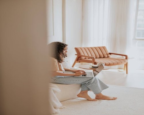Person typing comfortably on a laptop in a bright room